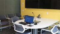Simulation Center debrief room with table, tv, and computer for instruction.